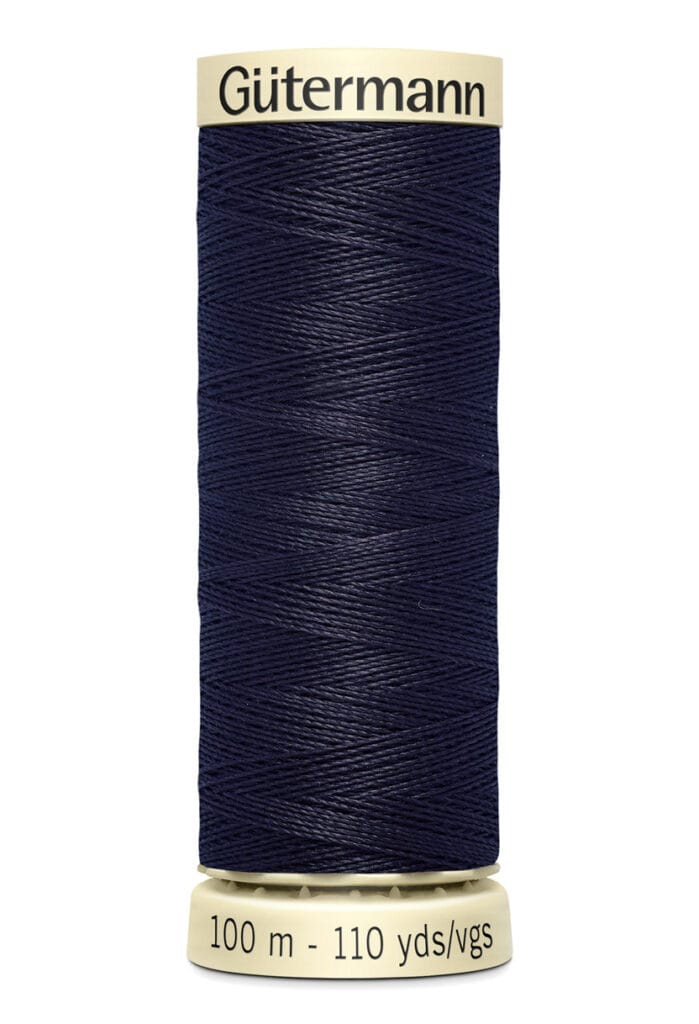 A spool of Gütermann dark blue sewing thread with cream-colored ends. The label indicates a length of 100 meters or 110 yards.