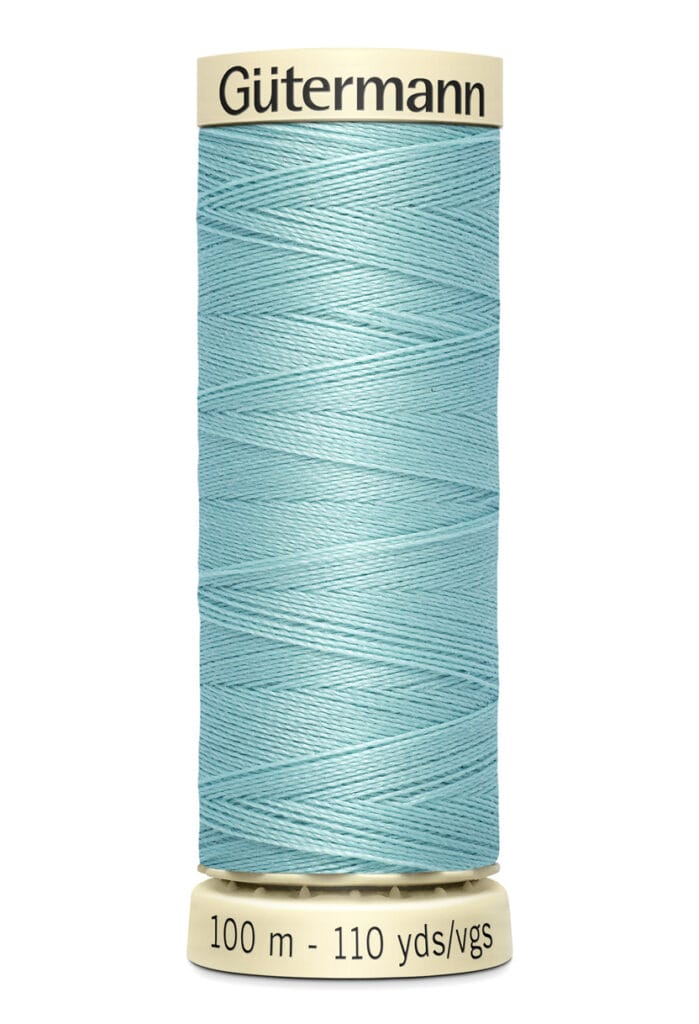 A spool of Gütermann thread in light blue, with a length of 100 meters or 110 yards. The spool has a beige top and bottom, and the brand name is printed on the top.