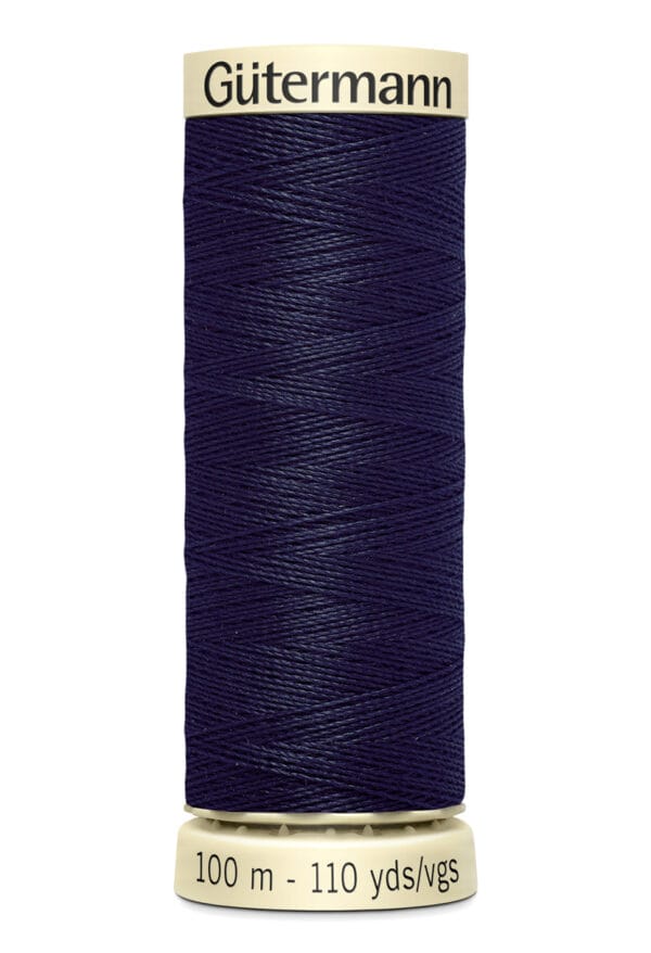 A spool of Gütermann navy blue thread is shown. The thread is neatly wound, and the spool has labels indicating it contains 100 meters or 110 yards of thread.