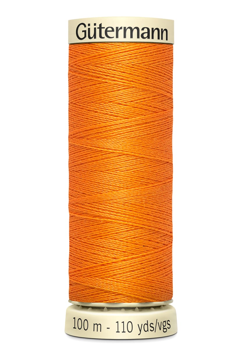 Art_788988_Col_350_150dpi A spool of Gütermann orange thread with a beige top and base. The text on the base indicates it contains 100 meters or 110 yards of thread.