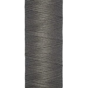 A spool of Gütermann thread in dark gray color, labeled with "100 m - 110 yds" at the bottom. The thread is neatly wound around a beige cylinder with the brand name displayed at the top.