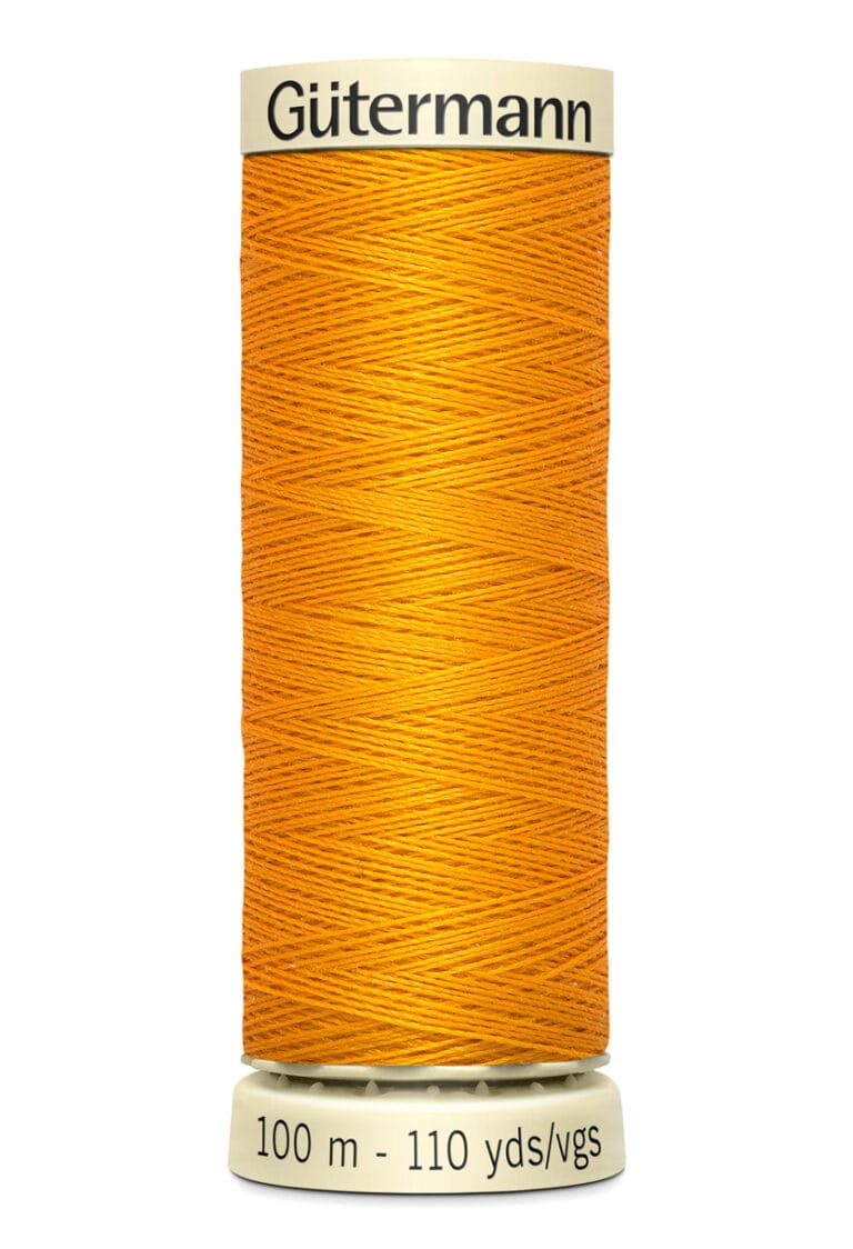 Spool of Gütermann orange thread, labeled with "100 m - 110 yds/vgs" at the base. The thread is neatly wound around the spool, creating a vivid contrast with the light-colored ends.