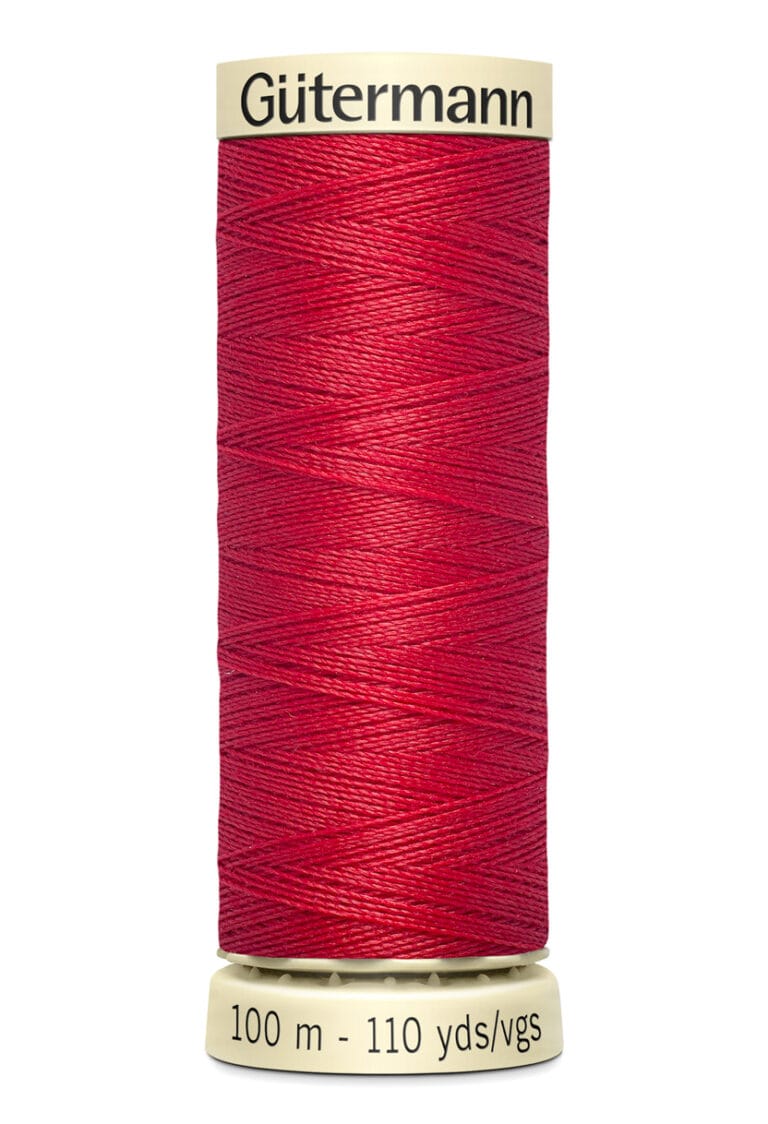 A spool of Gütermann red sewing thread stands upright. The label at the bottom indicates it contains 100 meters (110 yards) of thread.