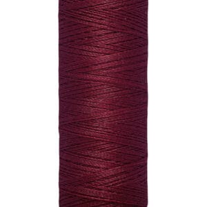 A spool of Gütermann thread in a deep burgundy color, with cream-colored labels at the top and bottom. The bottom label reads "100 m - 110 yds/vgs.