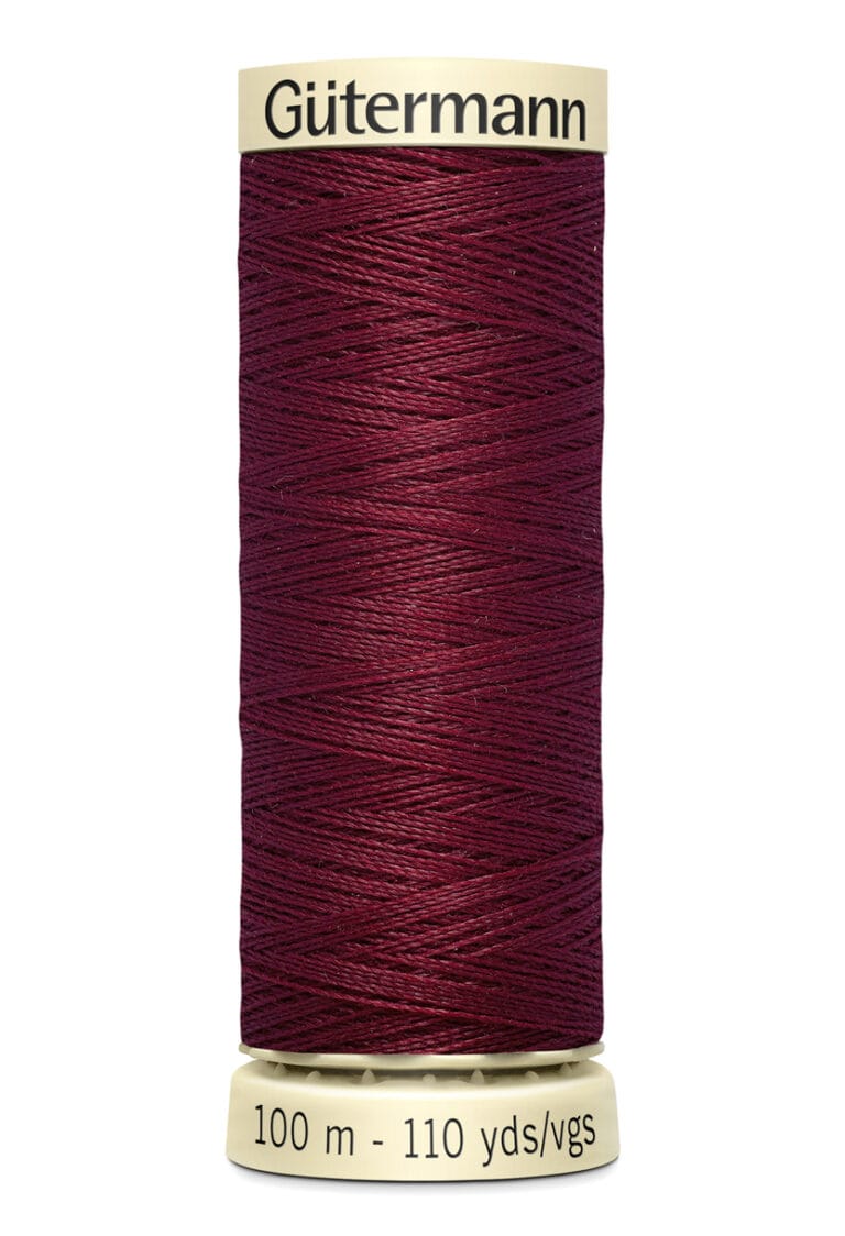 A spool of Gütermann thread in a deep burgundy color, with cream-colored labels at the top and bottom. The bottom label reads "100 m - 110 yds/vgs.