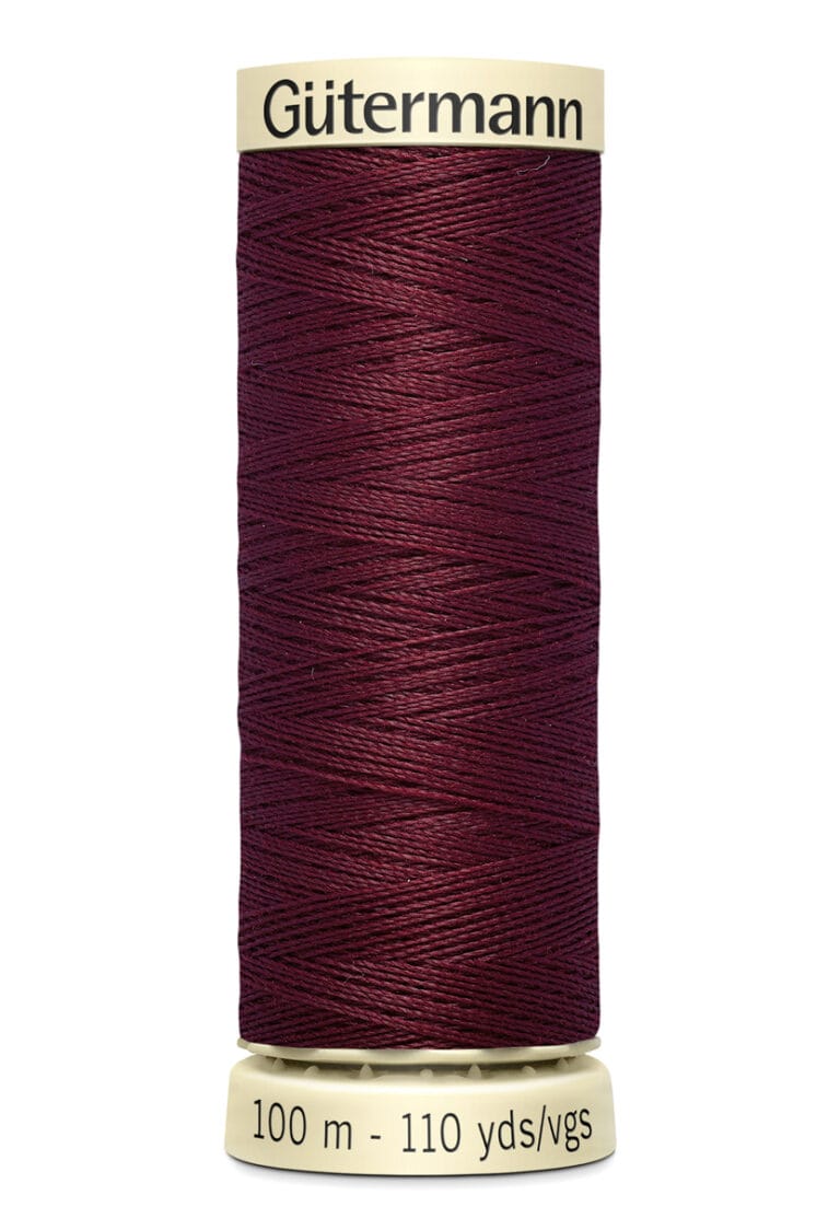 A spool of Gütermann thread with deep maroon color. It holds 100 meters (110 yards) of thread. The spool is beige with "Gütermann" written on the top and the length information on the bottom.