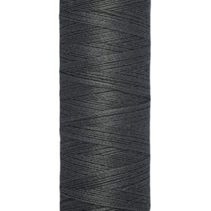 A spool of Gütermann black sewing thread with 100 meters (110 yards) of thread. The spool is cylindrical, with cream-colored ends featuring the brand name and measurement details.