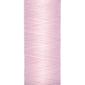 A spool of Gütermann pink sewing thread with a label indicating 100 meters (110 yards). The thread is neatly wound around a beige cylindrical holder.