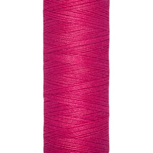 A spool of Gütermann thread in vibrant pink color. The label indicates the thread length as 100 meters or 110 yards. The thread is neatly wound around a cream-colored spool.