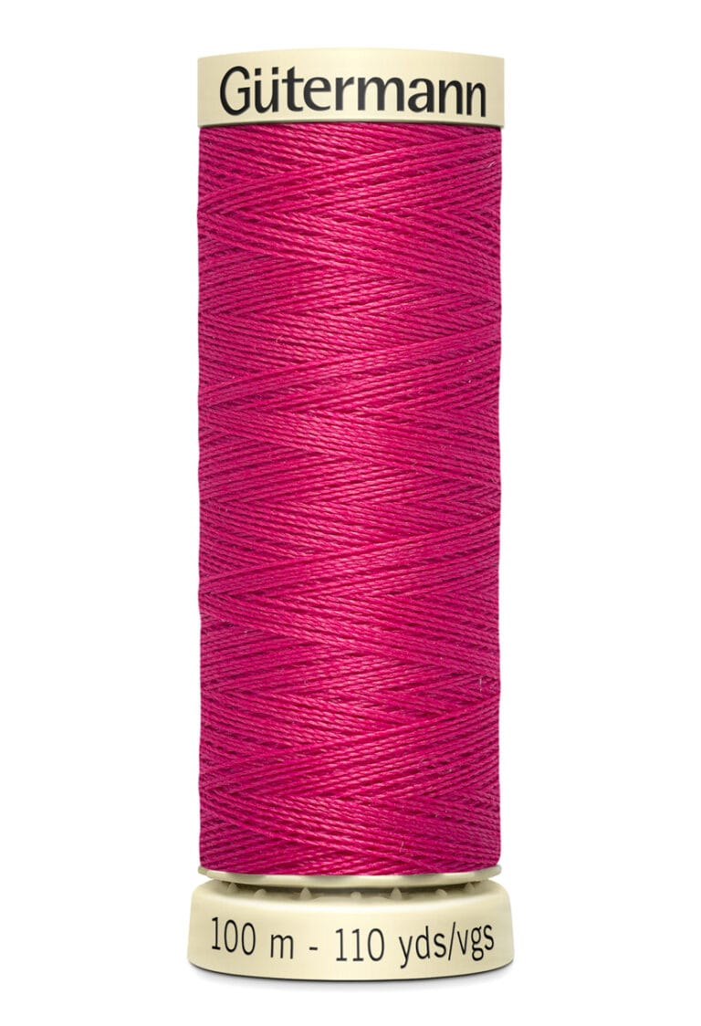 A spool of Gütermann thread in vibrant pink color. The label indicates the thread length as 100 meters or 110 yards. The thread is neatly wound around a cream-colored spool.