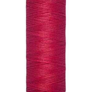A spool of Gütermann red sewing thread. The label shows it contains 100 meters or 110 yards of thread.