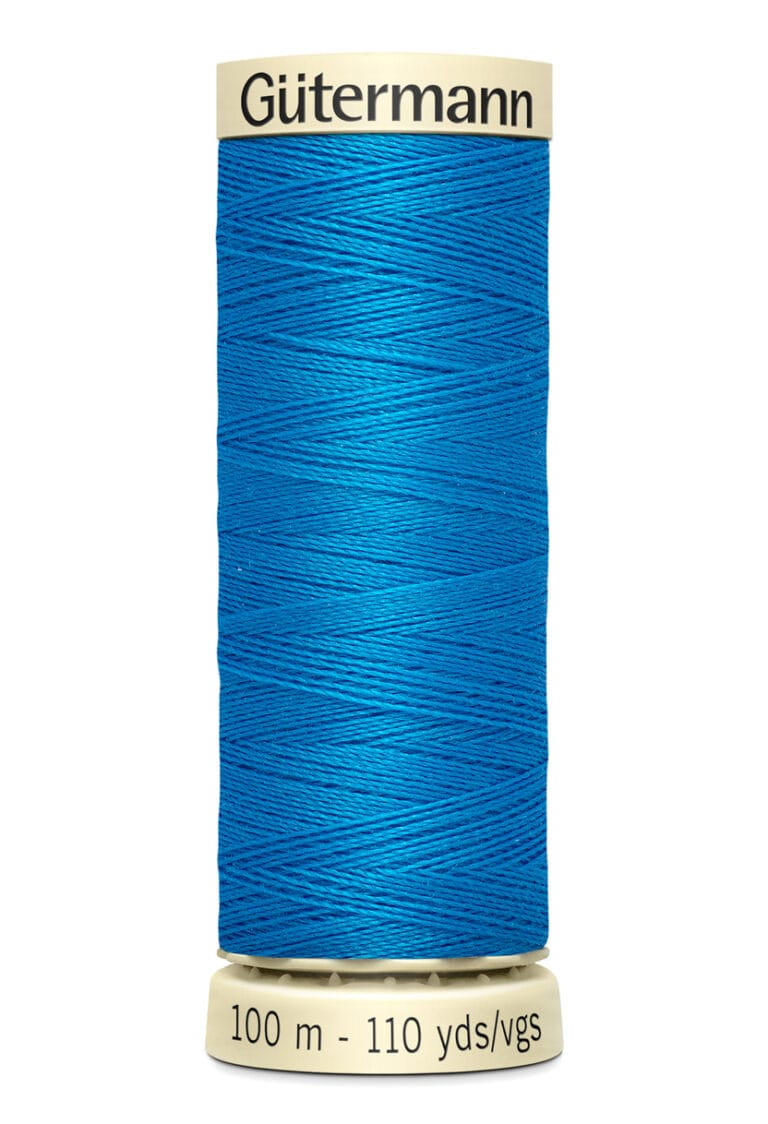 A spool of Gütermann blue sewing thread, with a label indicating 100 meters or 110 yards. The thread is wound tightly around a beige cylindrical spool.