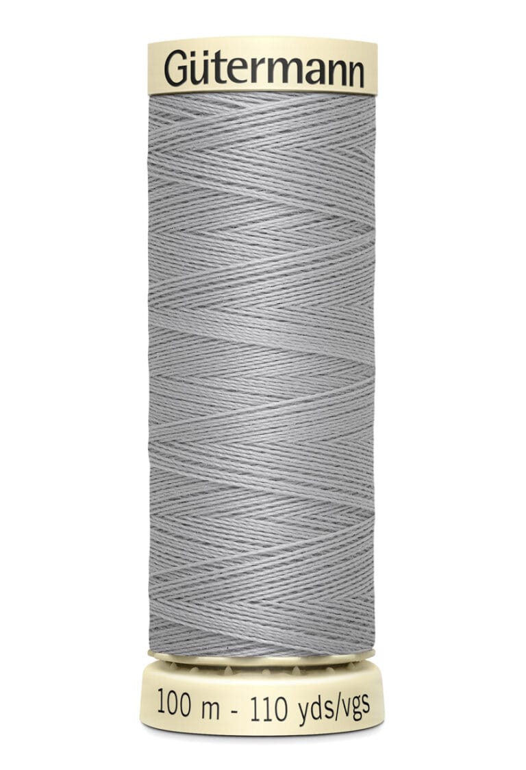 A spool of Gütermann thread, light gray in color, with 100 meters (110 yards) of polyester material. The spool is cylindrical with labeled ends displaying the brand name and thread length.