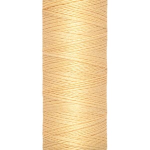 A spool of Gütermann thread in a light beige color, labeled with "100 m - 110 yds" on the base.
