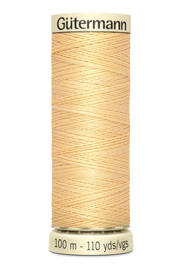 A spool of Gütermann thread in a light beige color, labeled with "100 m - 110 yds" on the base.