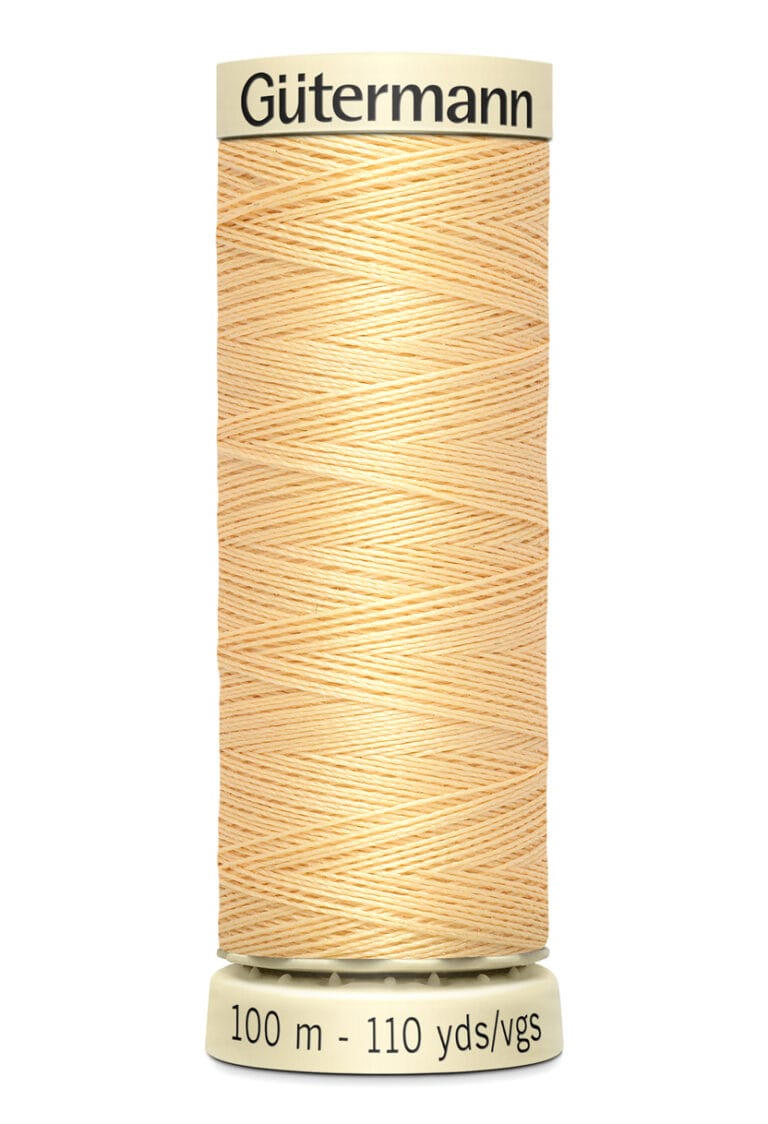 A spool of Gütermann thread in a light beige color, labeled with "100 m - 110 yds" on the base.