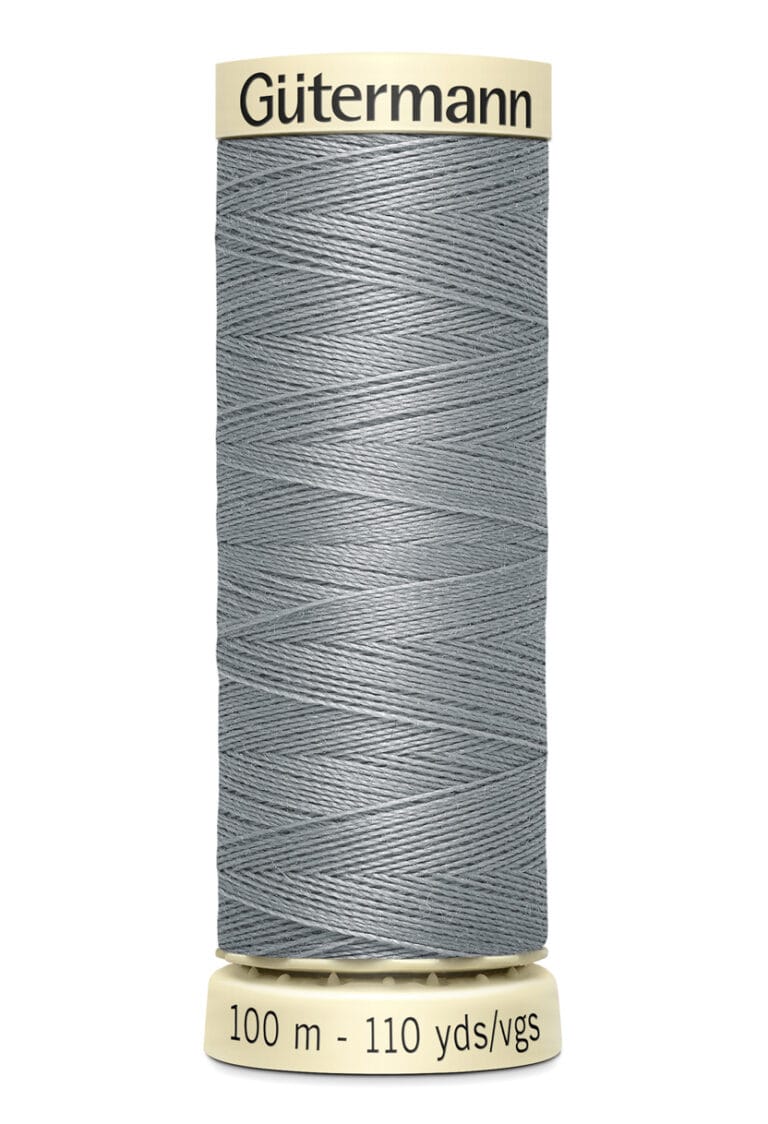 A spool of Gütermann gray sewing thread, labeled as 100 meters (110 yards). The thread is tightly wound around a beige spool with black text.