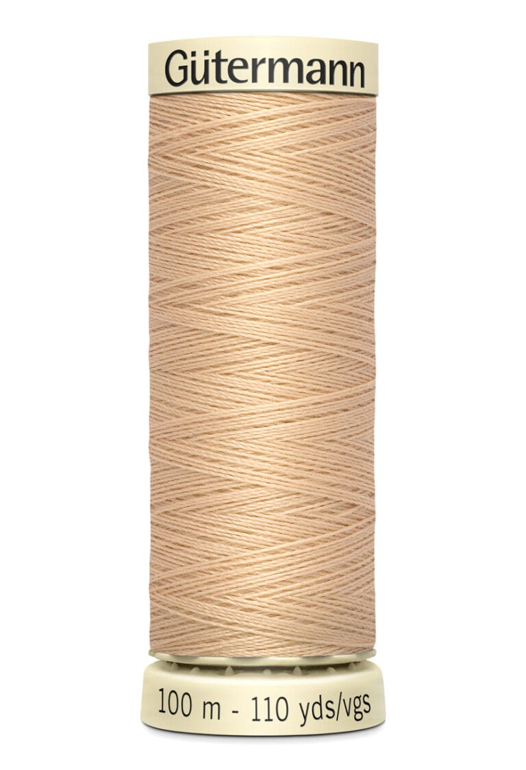 A spool of Gütermann beige sewing thread, labeled with "100 m - 110 yds," featuring tightly wound thread on a cylindrical holder.