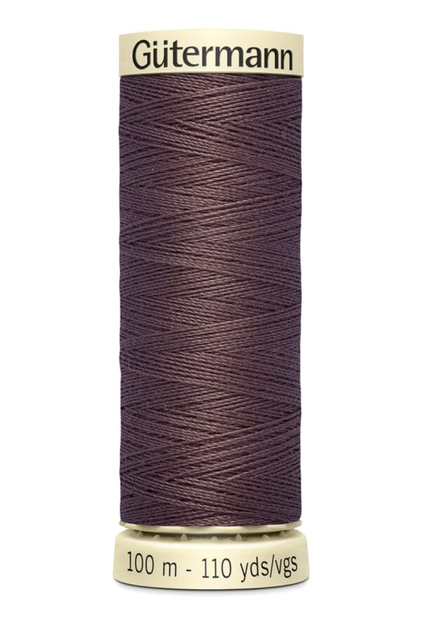 A spool of Gütermann sewing thread in dark brown, labeled for 100 meters or 110 yards. The spool is cylindrical with a beige top and bottom.