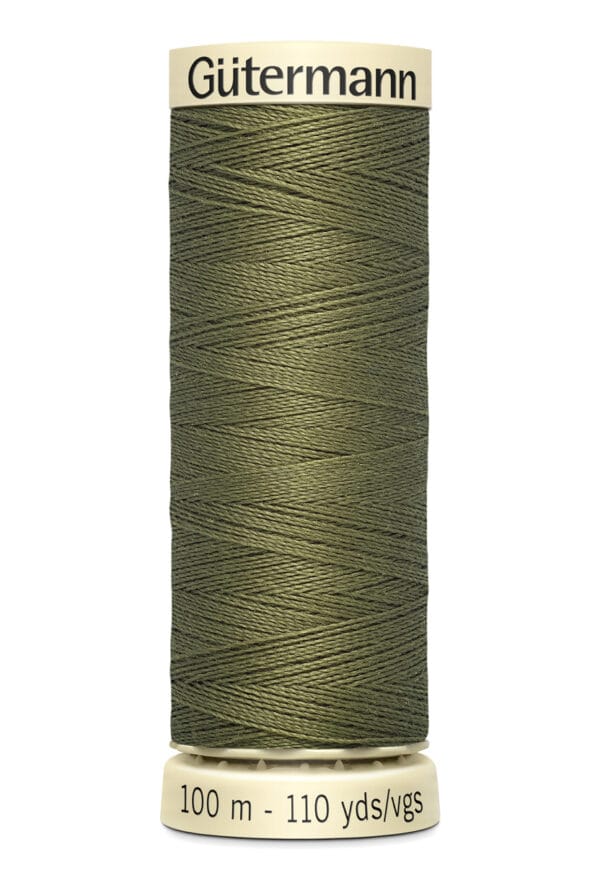 A spool of Gütermann green sewing thread is displayed vertically. The label indicates 100 meters (110 yards) of thread. The spool is beige, and the thread is neatly wound.