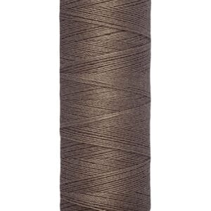 A spool of Gütermann sewing thread in dark brown color, featuring thin, tightly wound thread. The label indicates 100 meters or 110 yards per spool.