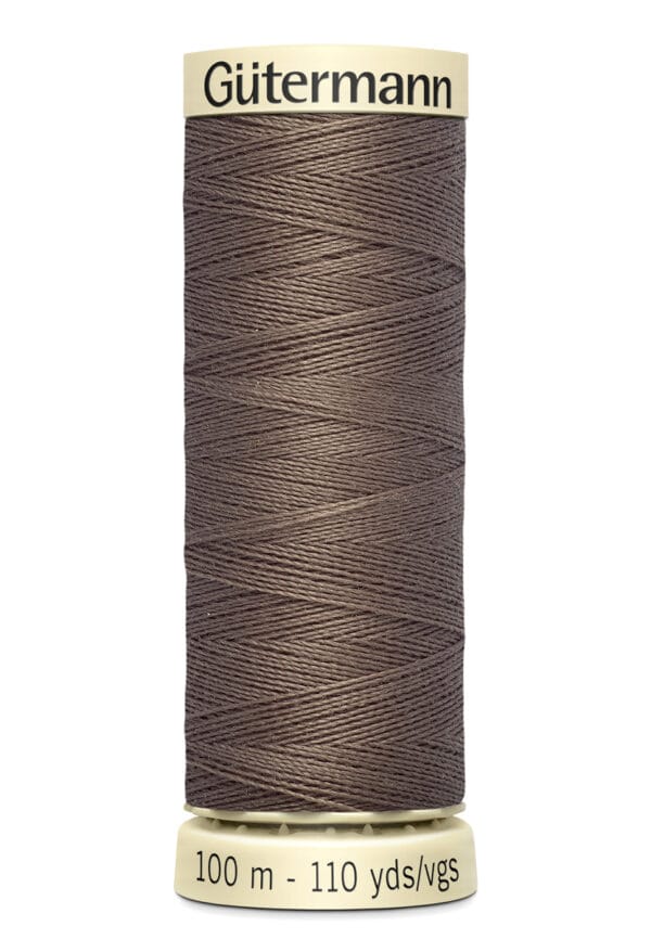 A spool of Gütermann sewing thread in dark brown color, featuring thin, tightly wound thread. The label indicates 100 meters or 110 yards per spool.