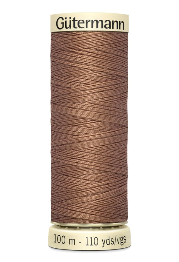 A spool of Gütermann thread in a tan color, wrapped neatly around a cylindrical core. The base reads "100 m - 110 yds/vgs" indicating the length of the thread.