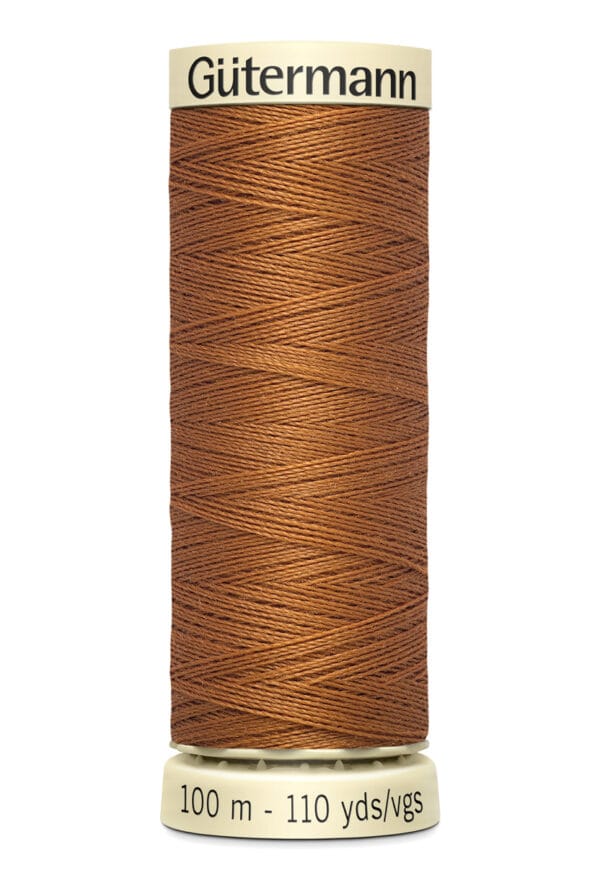 Close-up of a spool of Gütermann thread, brown in color. The spool displays "100 m - 110 yds/vgs" at the bottom, indicating the length of the thread.