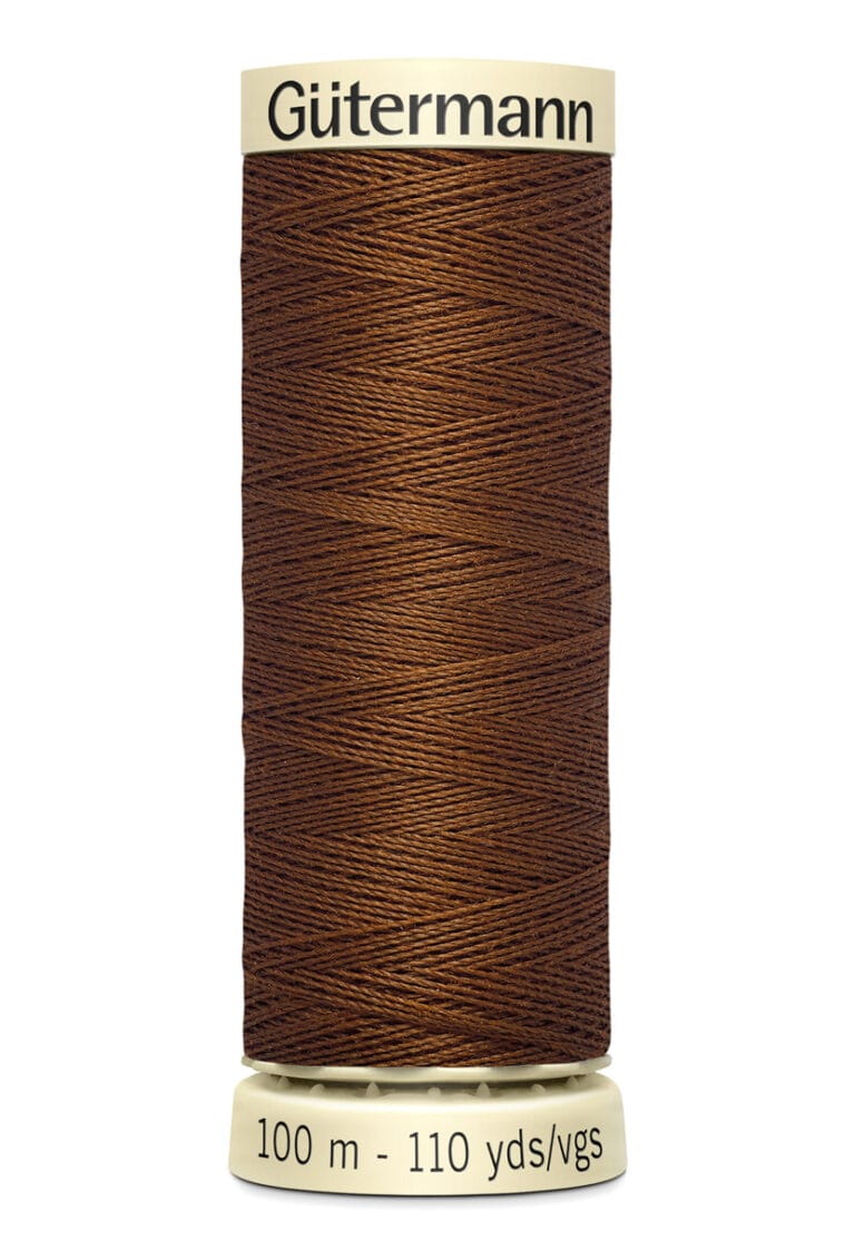 A spool of Gütermann brown sewing thread, labeled with "100 m - 110 yds" on the bottom and "Gütermann" on the top. The thread is tightly wound around a cream-colored spool.