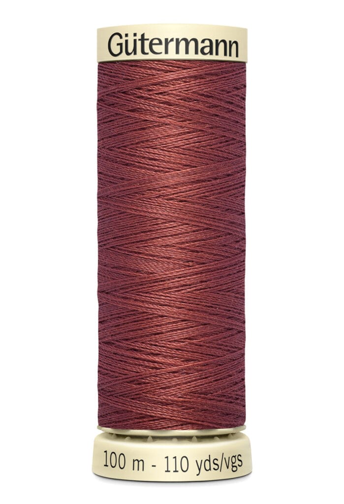 A spool of Gütermann thread in a deep brown color. The spool is neutral in color and shows measurements of 100 meters and 110 yards.