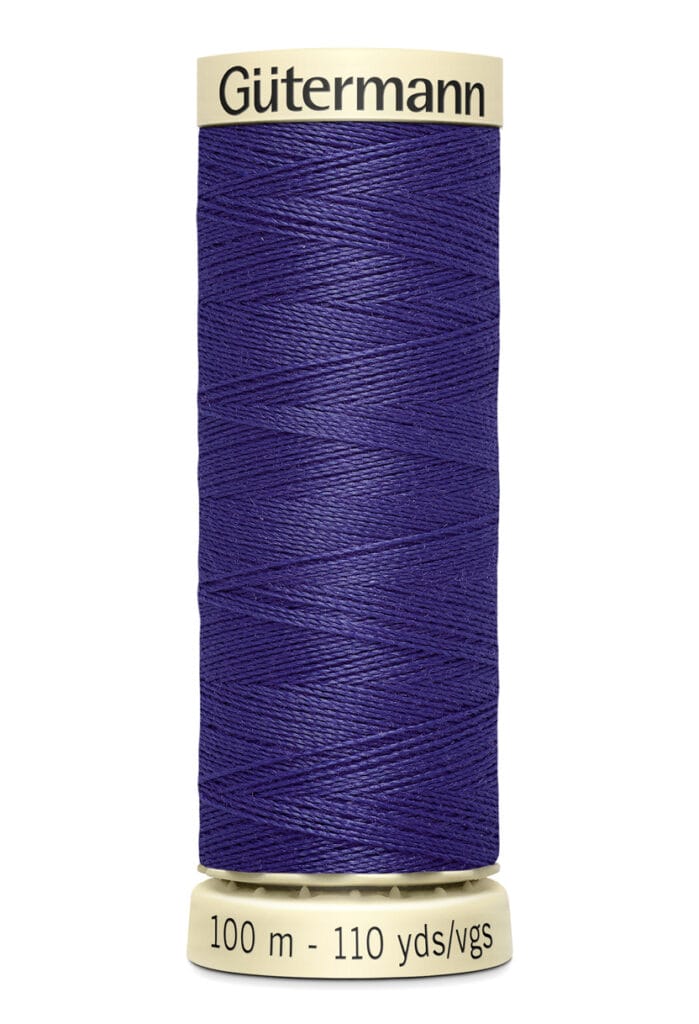 A spool of Gütermann sewing thread in dark blue. The spool is labeled with "100 m - 110 yds/vgs" and has a light beige top and bottom. The thread is wound neatly.