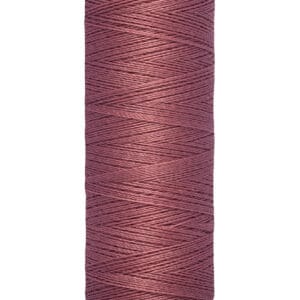A spool of Gütermann thread in a muted mauve color. The spool holds 100 meters or 110 yards of thread. The base and top of the spool are cream-colored.
