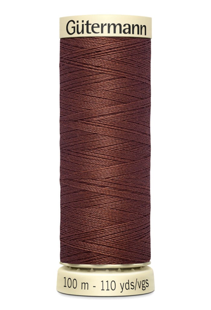 Spool of Gütermann brown thread, 100 meters (110 yards), on a beige holder.