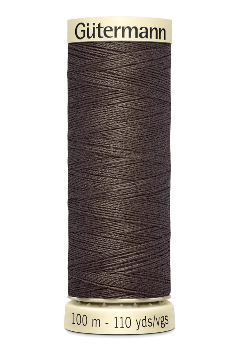 A spool of Gütermann thread in brown, with labels indicating 100 meters and 110 yards. The thread is neatly wound around a beige cylindrical spool.