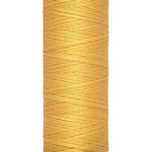 A spool of Gütermann sewing thread in a golden tan color, marked with "100 m - 110 yds/vgs," with black text on the label at the top and bottom. The thread is tightly wound around the spool.