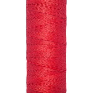 A spool of Gütermann red sewing thread, 100 meters or 110 yards, is displayed vertically. The thread is tightly wound around a beige spool with the brand name at the top.