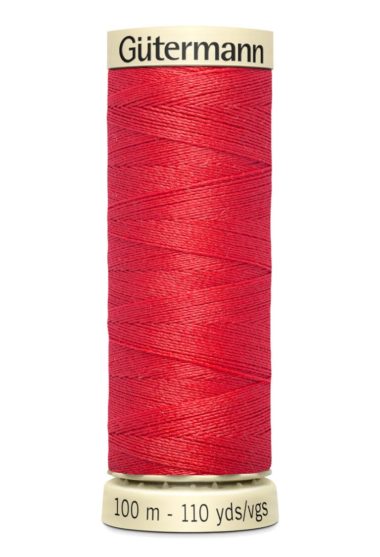 A spool of Gütermann red sewing thread, 100 meters or 110 yards, is displayed vertically. The thread is tightly wound around a beige spool with the brand name at the top.