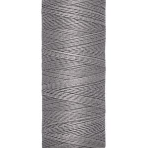Spool of Gütermann thread, gray in color, with labeling indicating 100 meters or 110 yards of thread. The spool is upright, with beige ends and crisscrossing thread visible.