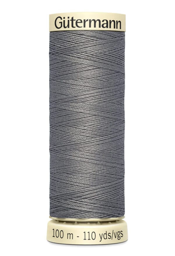 A spool of Gütermann gray sewing thread, 100 meters or 110 yards, with beige ends.