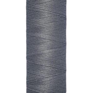 A spool of Gütermann sewing thread in gray, wrapped neatly around a beige spool with a label indicating "100 m - 110 yds/vgs.