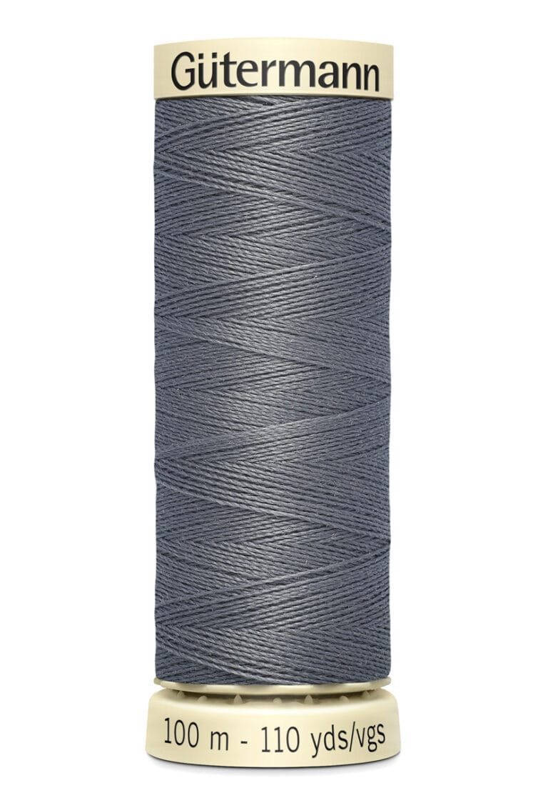 A spool of Gütermann sewing thread in gray, wrapped neatly around a beige spool with a label indicating "100 m - 110 yds/vgs.