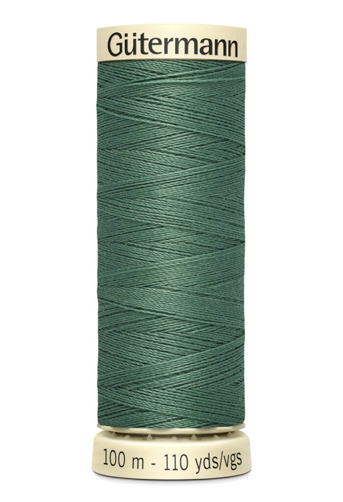 A spool of Gütermann sewing thread in dark green, labeled with "100 m - 110 yds" on the base. The spool is cylindrical with a beige top and bottom.