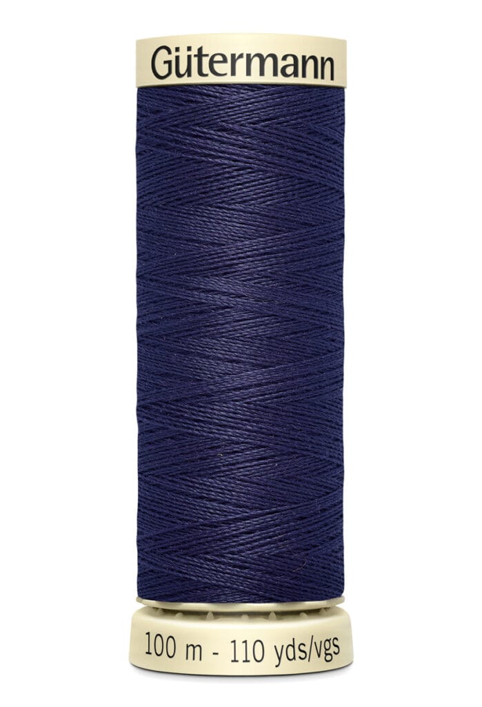 Spool of Gütermann navy blue thread with cream-colored top and bottom. The label reads "100 m - 110 yds.