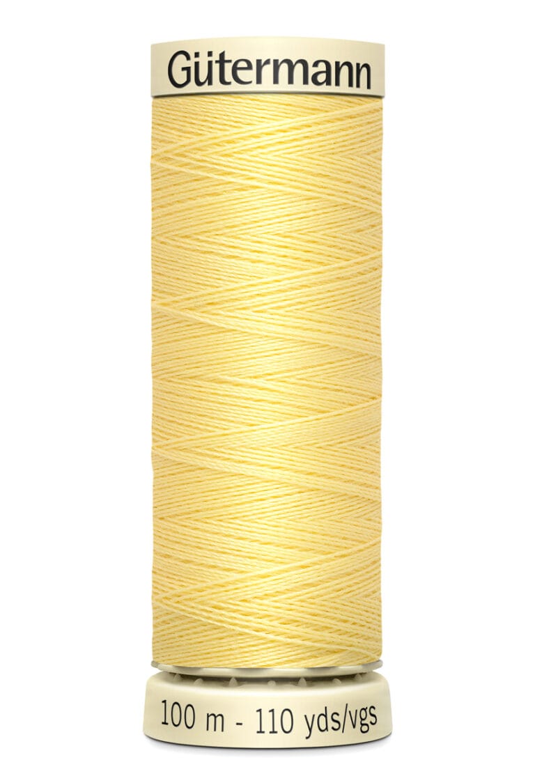 A spool of Gütermann sewing thread with pale yellow color. The label indicates 100 meters, 110 yards.