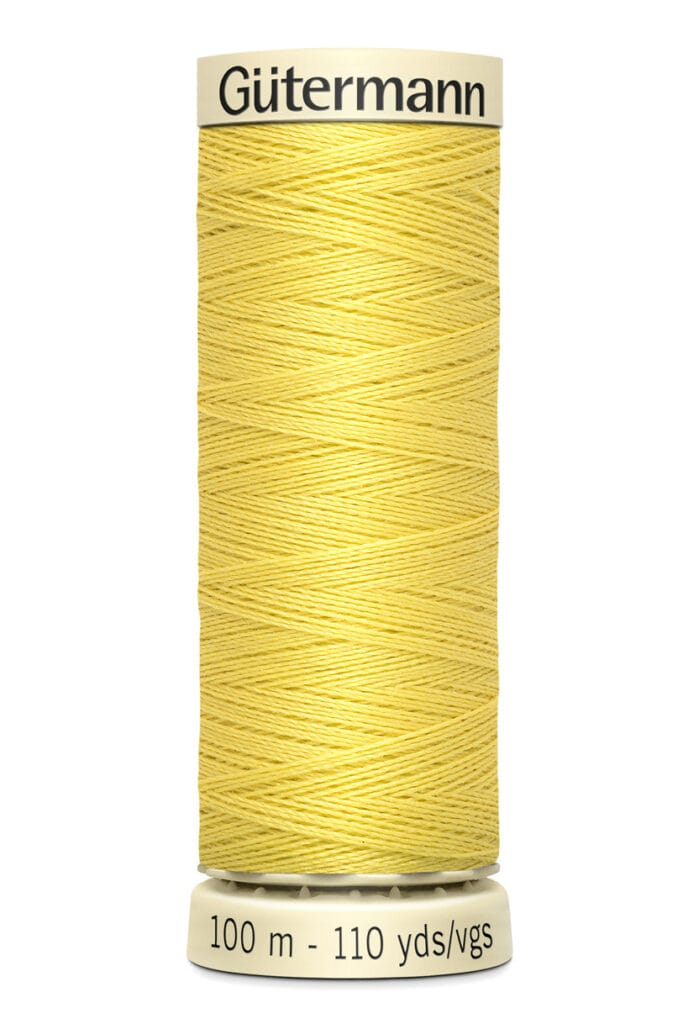 A spool of Gütermann sewing thread in a pale yellow color. The spool label indicates the thread length as 100 meters or 110 yards.