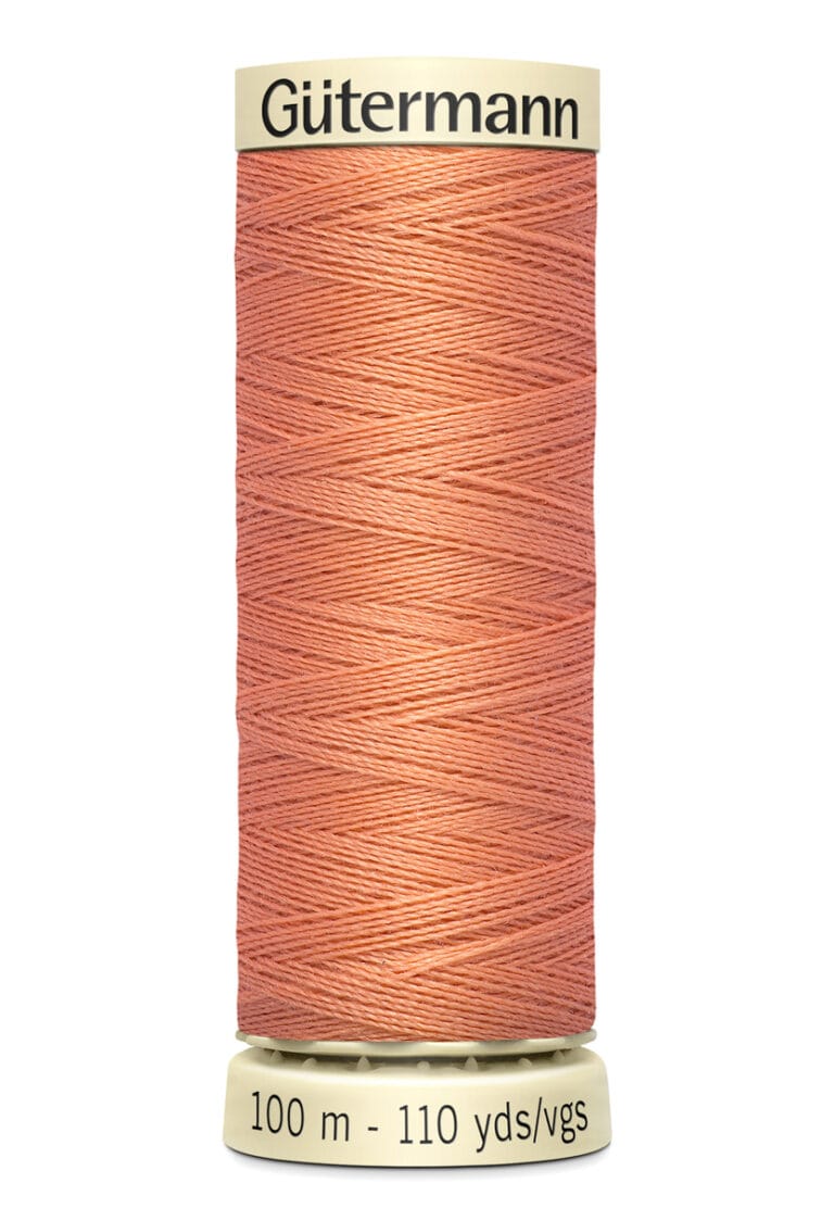 A spool of Gütermann thread in peach color, showing a label indicating 100 meters or 110 yards.