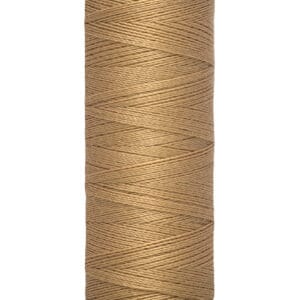 A spool of Gütermann sewing thread in a light brown color, labeled for 100 meters and 110 yards. The thread is neatly wound around the spool, with a cream-colored base and top.