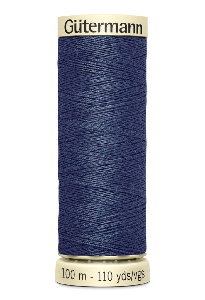 A spool of Gütermann sewing thread in dark blue. The label indicates it contains 100 meters or 110 yards of thread. The spool has a yellowish base and top.