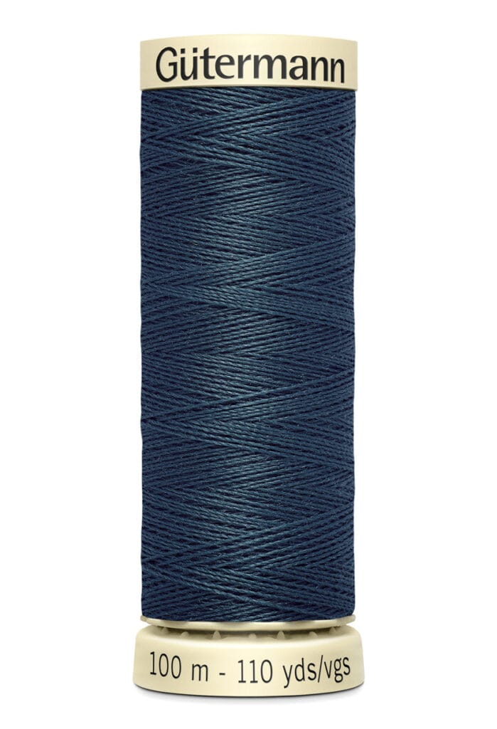 A spool of Gütermann thread in dark blue. The label reads "100 m - 110 yds/vgs" and the spool has a beige base and top.