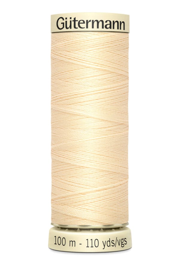 A spool of Gütermann thread in a light cream color, labeled with 100 meters or 110 yards. The thread is neatly wound on a beige plastic spool.